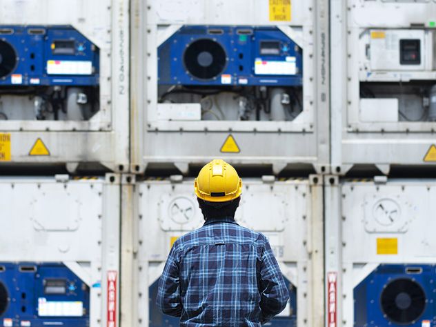 a man standing in front of reefer containers